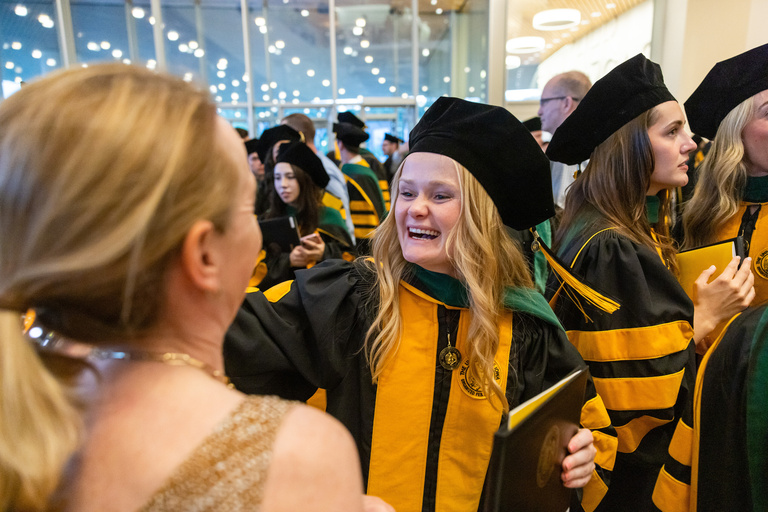 MD graduate celebrates the MD commencement ceremony with others.