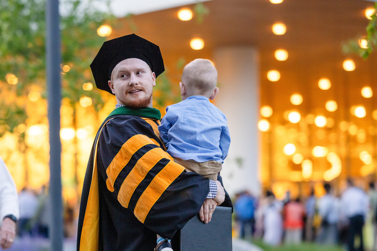 MD graduate celebrates the MD commencement ceremony with his son.